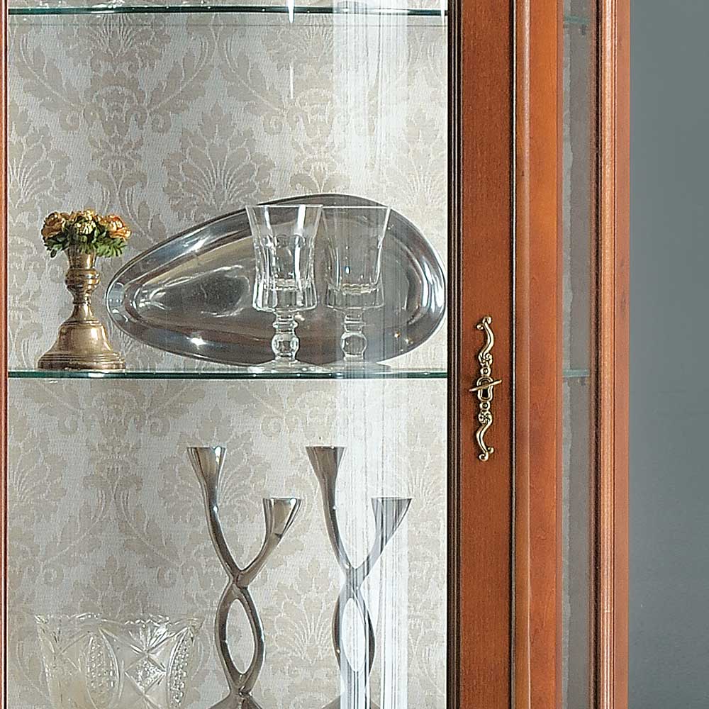 Innenansicht der Glasvitrine mit gemusterter Rückwand und elegantem Türgriff im Barockstil – Dentro
