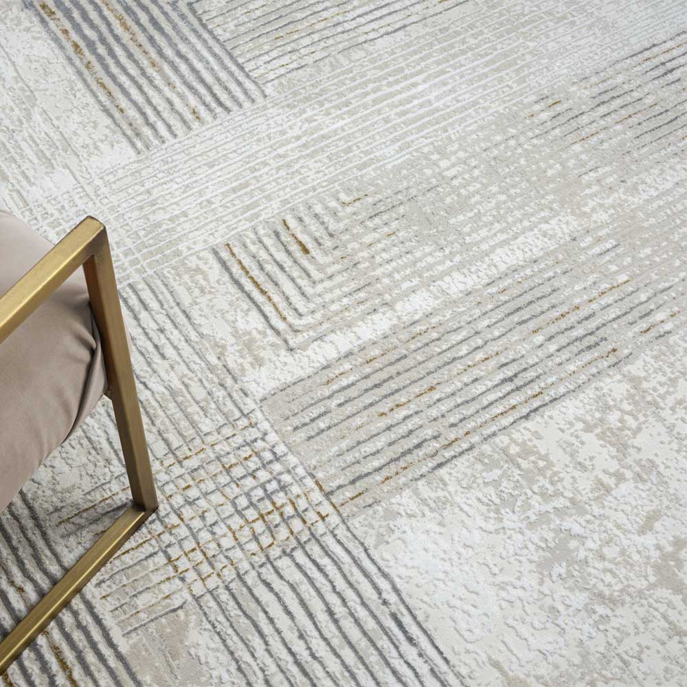 Detailansicht des Teppichmusters mit feinen Linien in Creme, Hellgrau und Goldtönen – Sascora