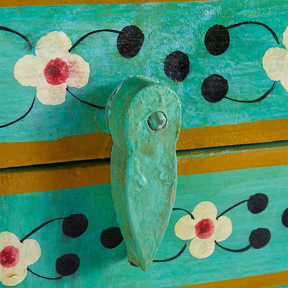 Grüner Türgriff am Vintage Schrank mit Blumen- und Punktmuster auf türkiser Oberfläche – Lennlo
