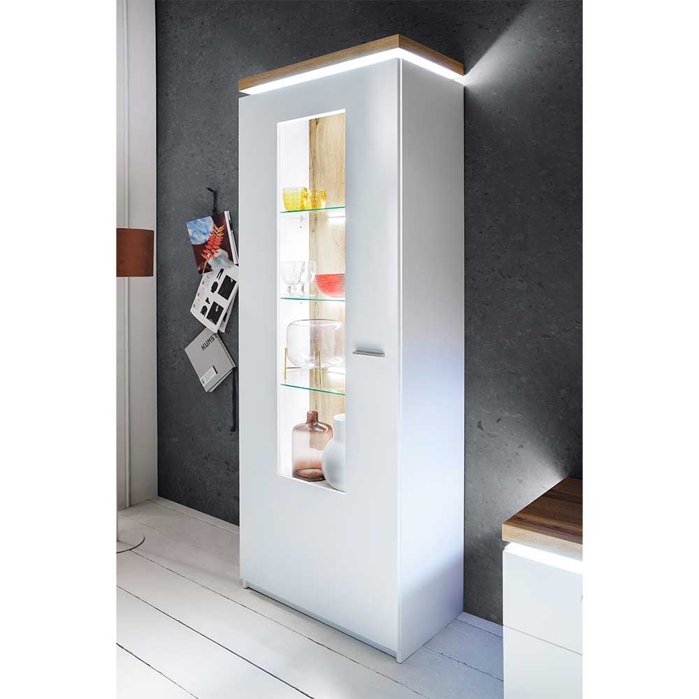 Weiße Wohnzimmervitrine mit Glaseinsatz, Holzplatte und LED-Beleuchtung im Raum – Caldri