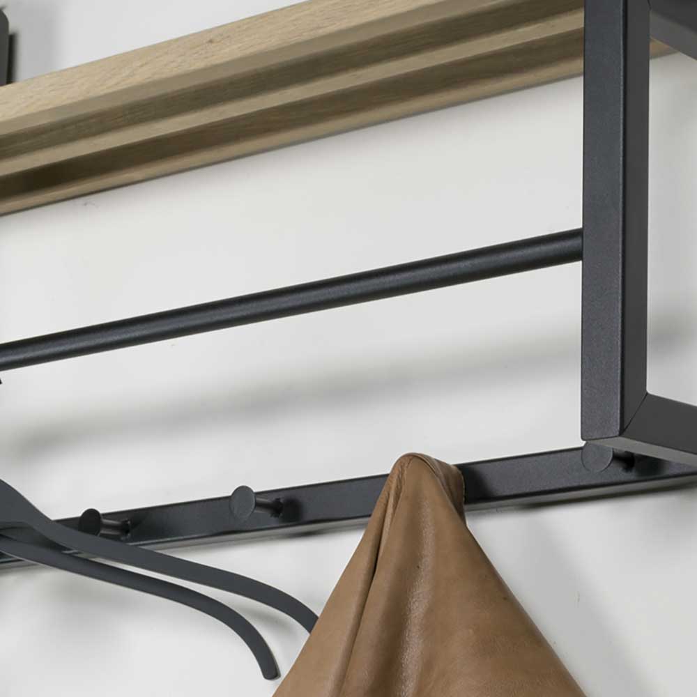 Schwarze Kleiderhaken und Garderobenstange mit brauner Jacke am Stahlgestell der Garderobe – Lundreo