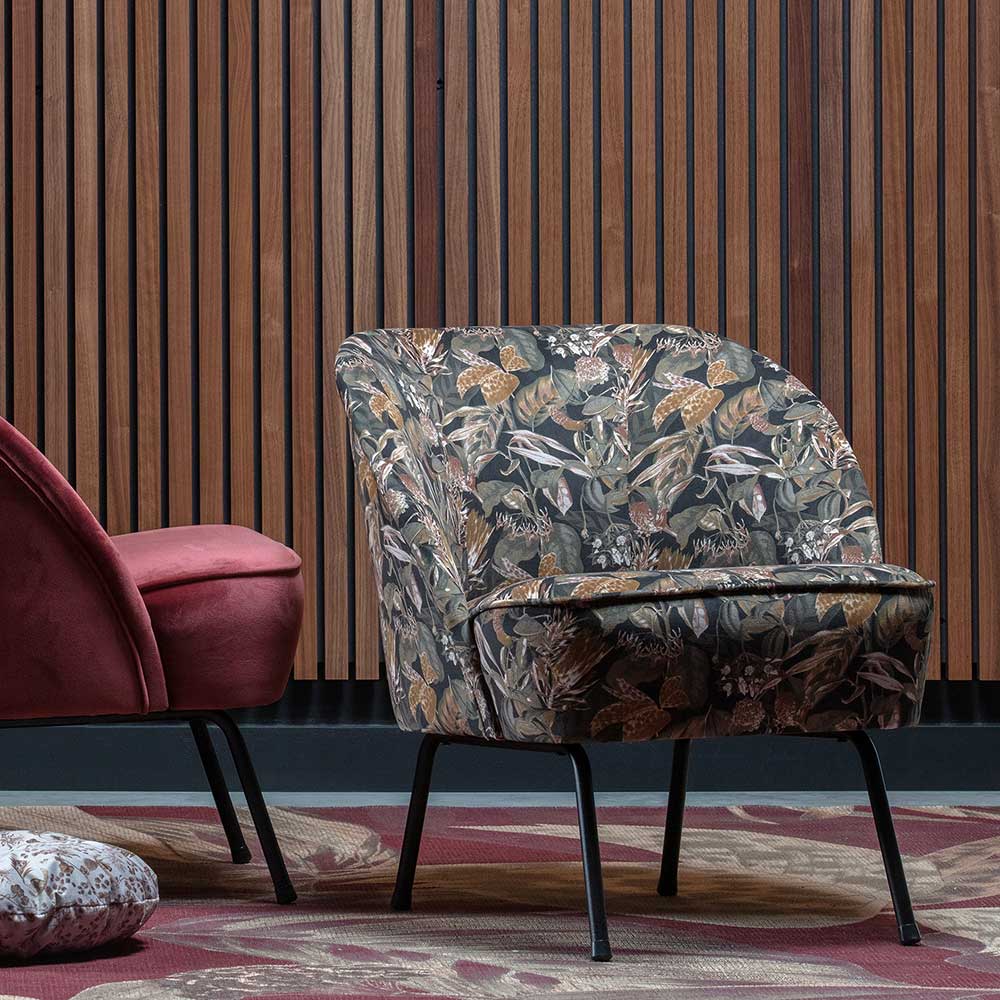 Designsessel mit Pflanzenmuster in einem modernen Wohnambiente vor einer Holzvertäfelung – Zimcons