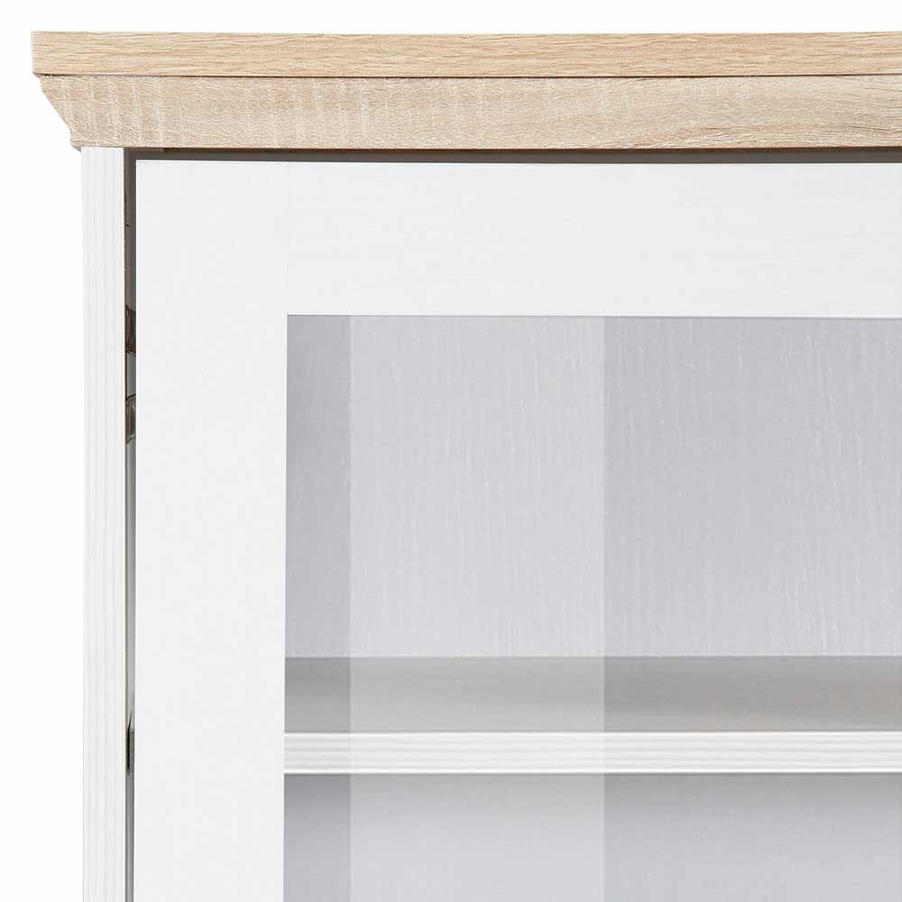 Eckdetail des Landhaus Highboards mit heller Holzplatte und oberer Vitrinentür aus Glas – Akedra