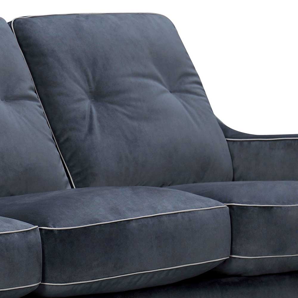 Detail der blauen Samtpolsterung mit Knopfheftung und weißen Ziernähten des Design Sofas – Sesedra