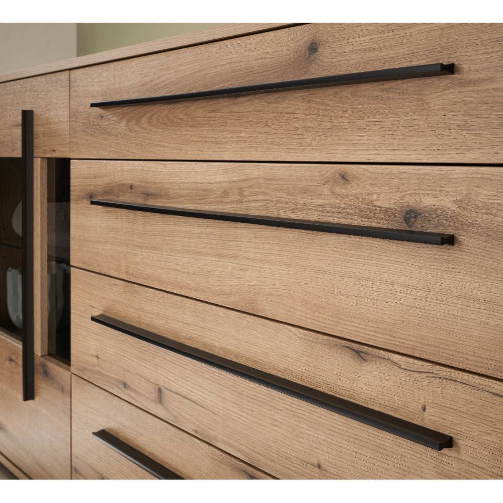 Vier Holzschubladen des Sideboards mit langen schwarzen Metallgriffen und deutlicher Maserung – Brocus