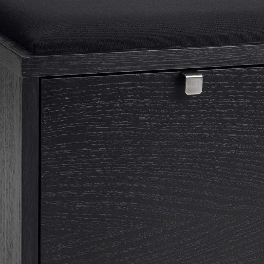 Detail der schwarzen Holzmaserung und des eleganten silbernen Schubladengriffs der Bank – Geskan
