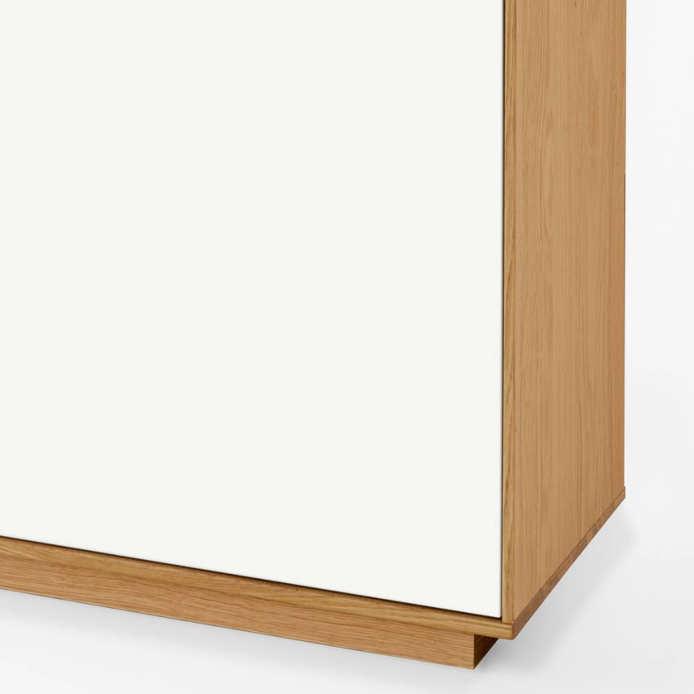 Zweifarbiges Flur-Highboard Detail mit weißer Türfront und hellem Holzsockel – Pablona