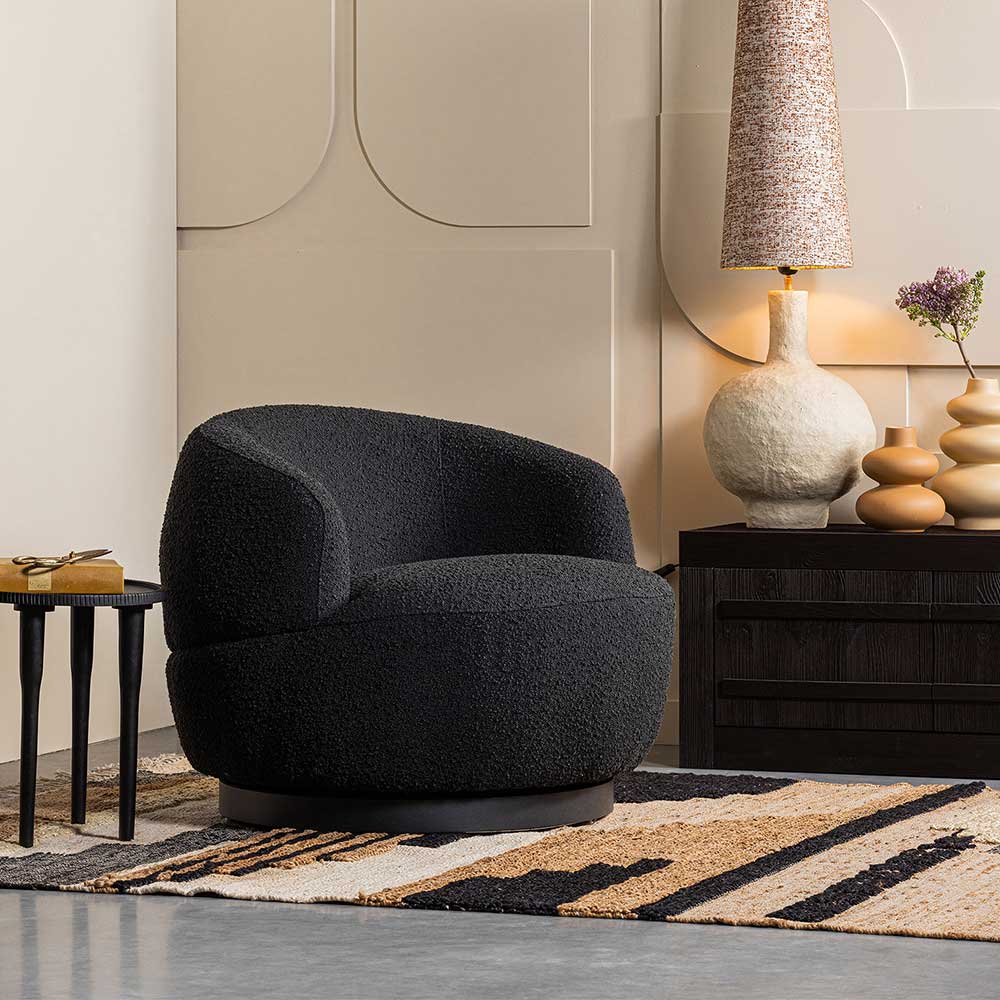Gemusterter Ethno-Teppich aus Naturmaterialien für das Wohnzimmer unter einem Sessel – Jesuisa