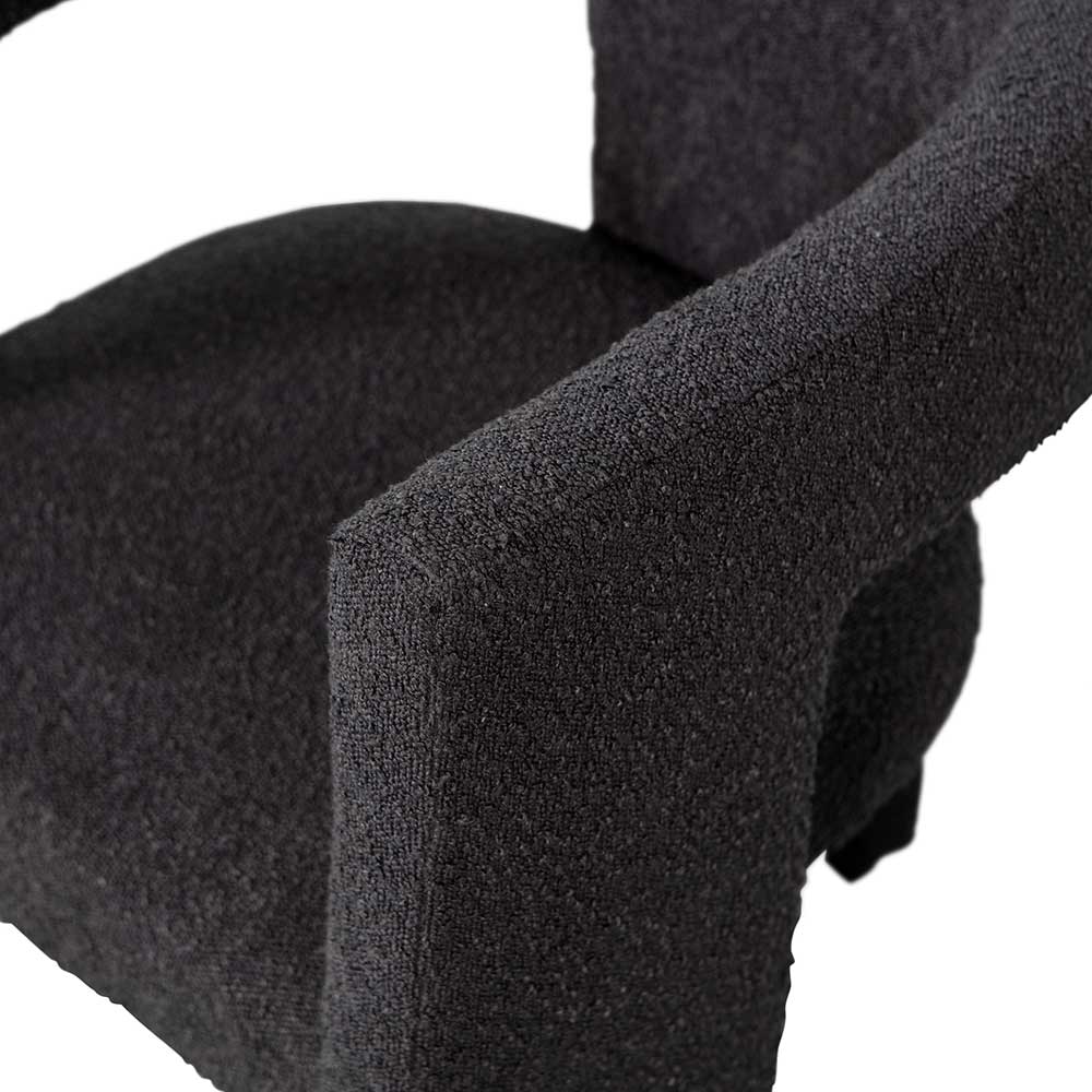 Breite Armlehne und bequeme Sitzfläche des dunkelgrauen Boucle Sessels – Seanno