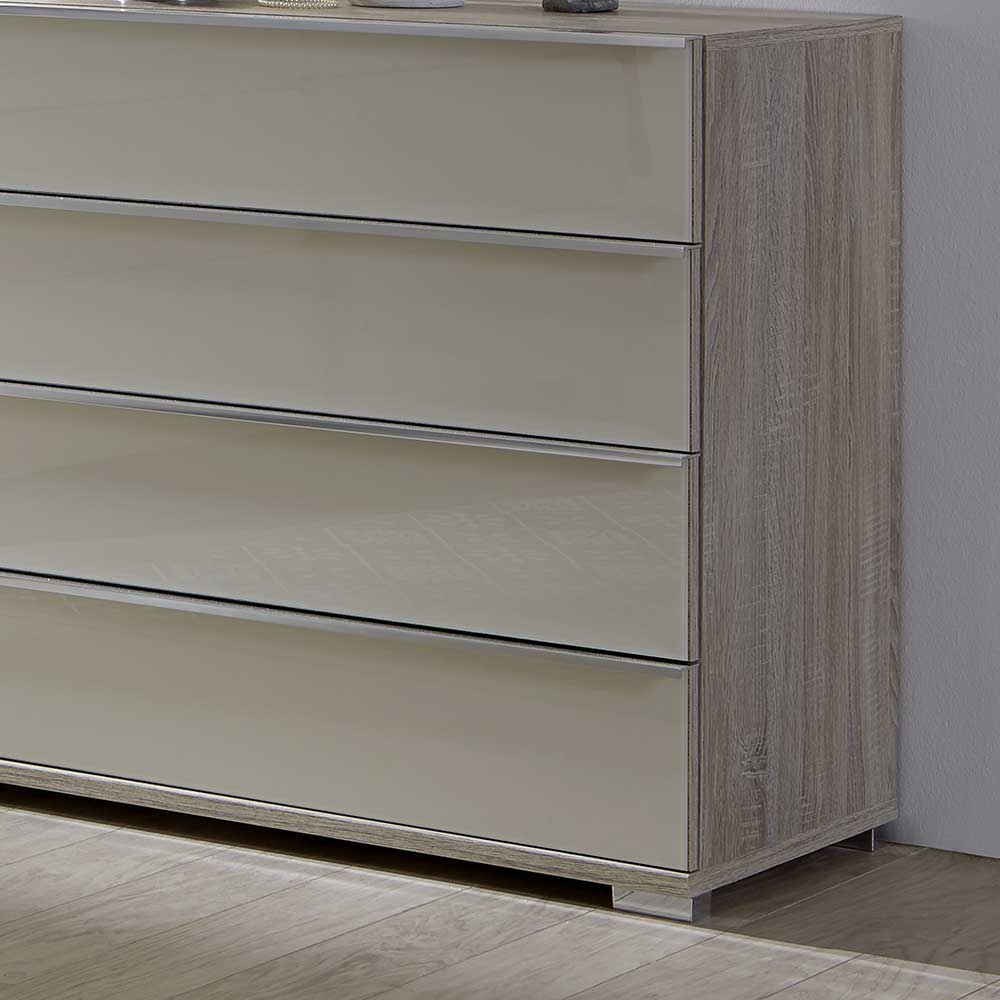 Glänzendes Sideboard Detail mit creme weißen Glasfronten und heller Holzoptik – Monchy