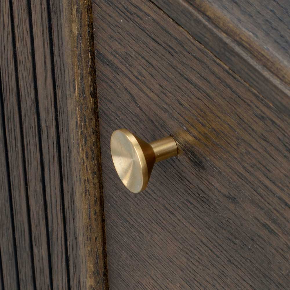 Konischer goldener Messingknopf der Schublade des dunklen Eichenholz Sideboards im Nahfokus – Cuzliav