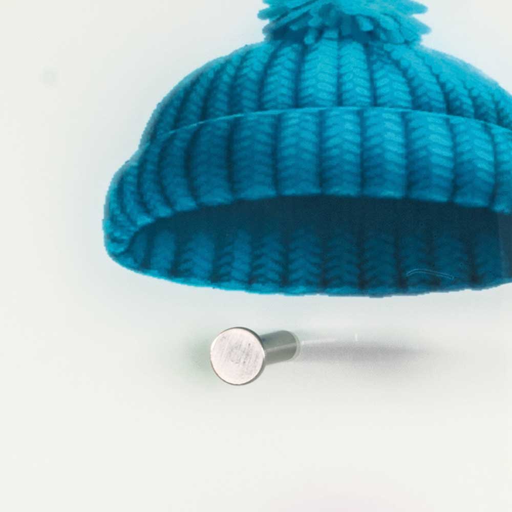 Blaue Strickmütze auf eleganter Glasgarderobe mit glänzendem silbernem Haken – Trujano