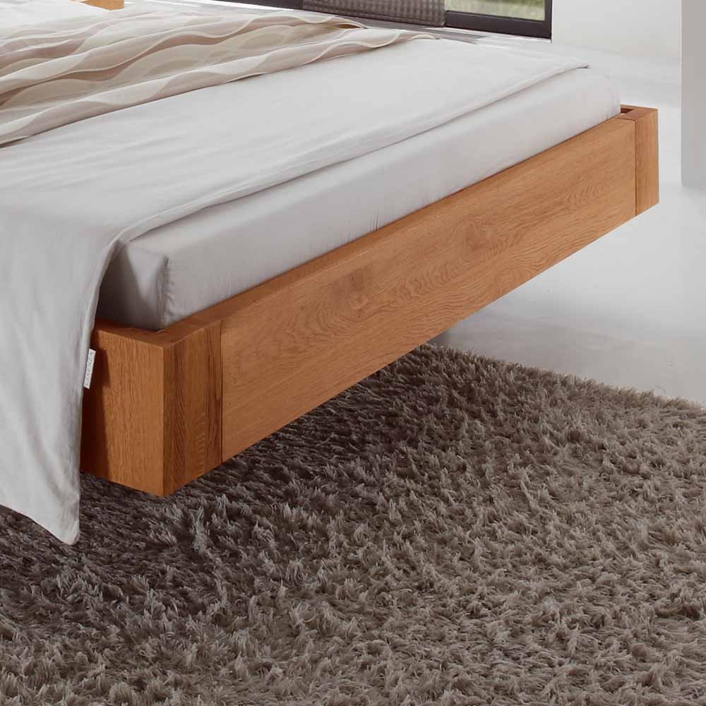 Schwebendes Massivholz-Ehebett mit elegantem Holzrahmen und weißer Bettwäsche im Schlafzimmer – Melli