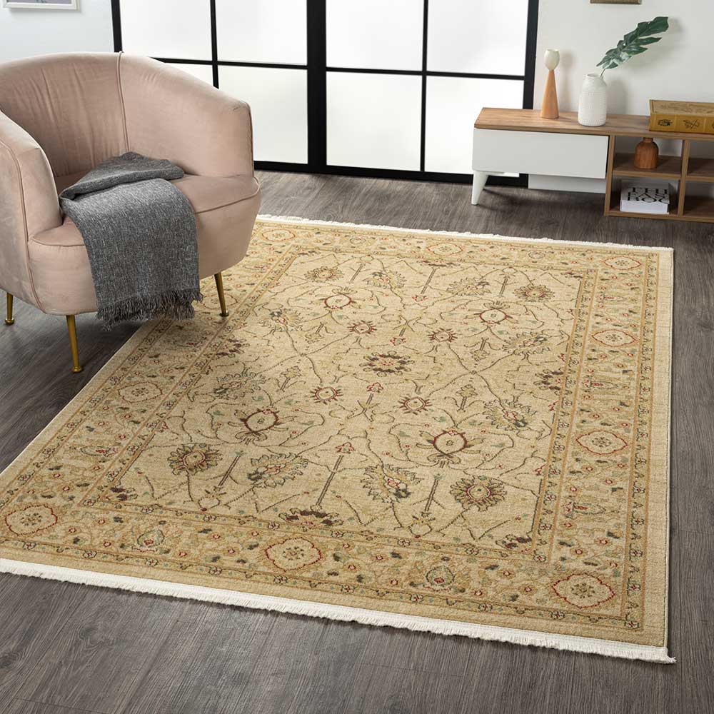 Beiger Orientteppich im Wohnzimmer vor einem Sessel mit floralen Ornamenten – Arjas