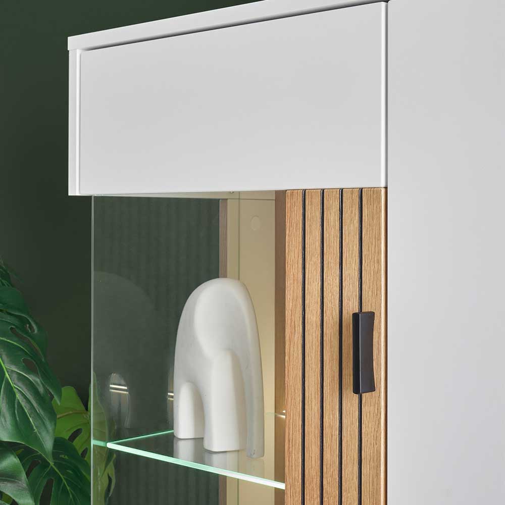 Glaseinsatz der Vitrine mit LED-Beleuchtung und Holzwand des Highboards – Nenaloro