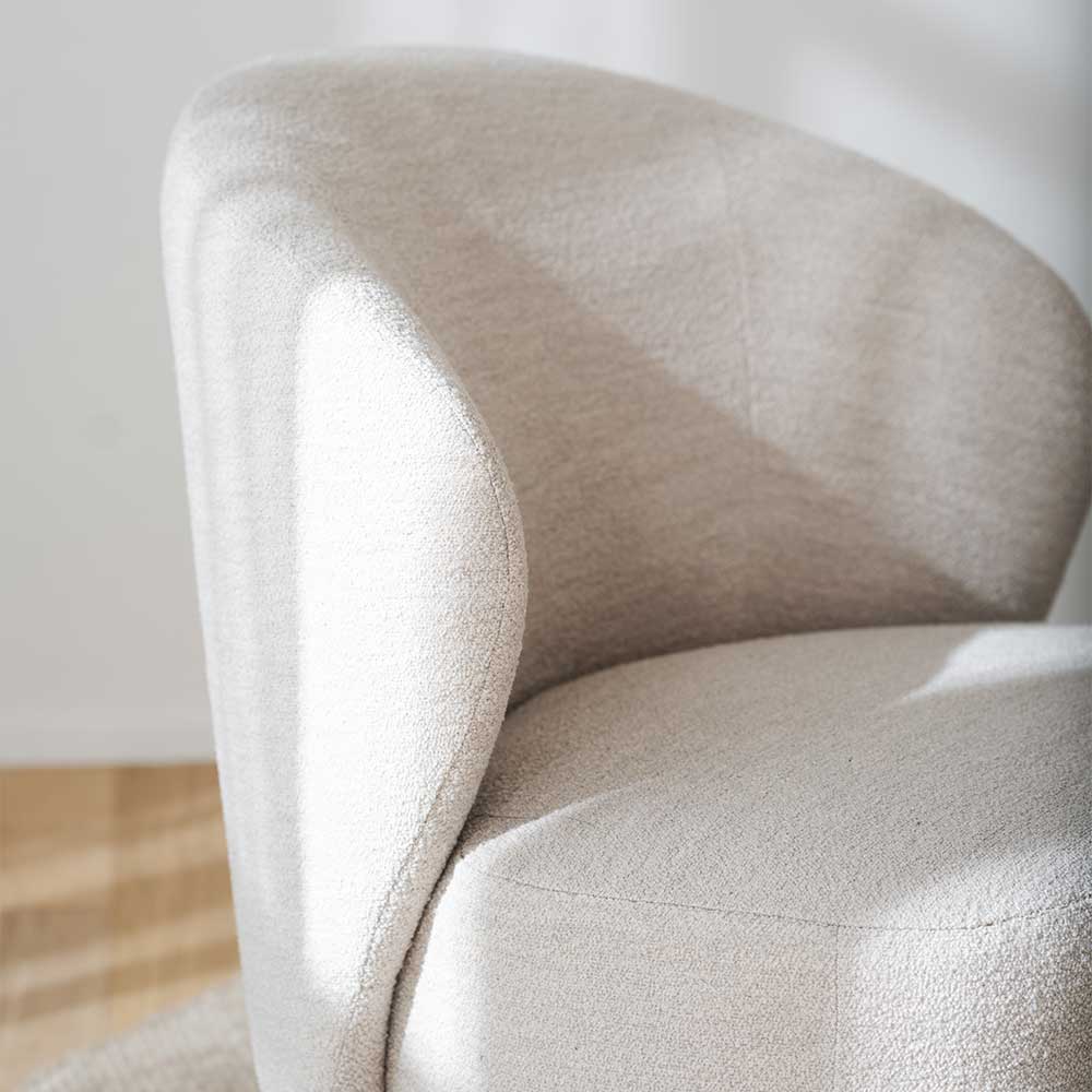 Nahaufnahme des cremeweißen Boucle Stoffes und der geschwungenen Rückenlehne – Cleas