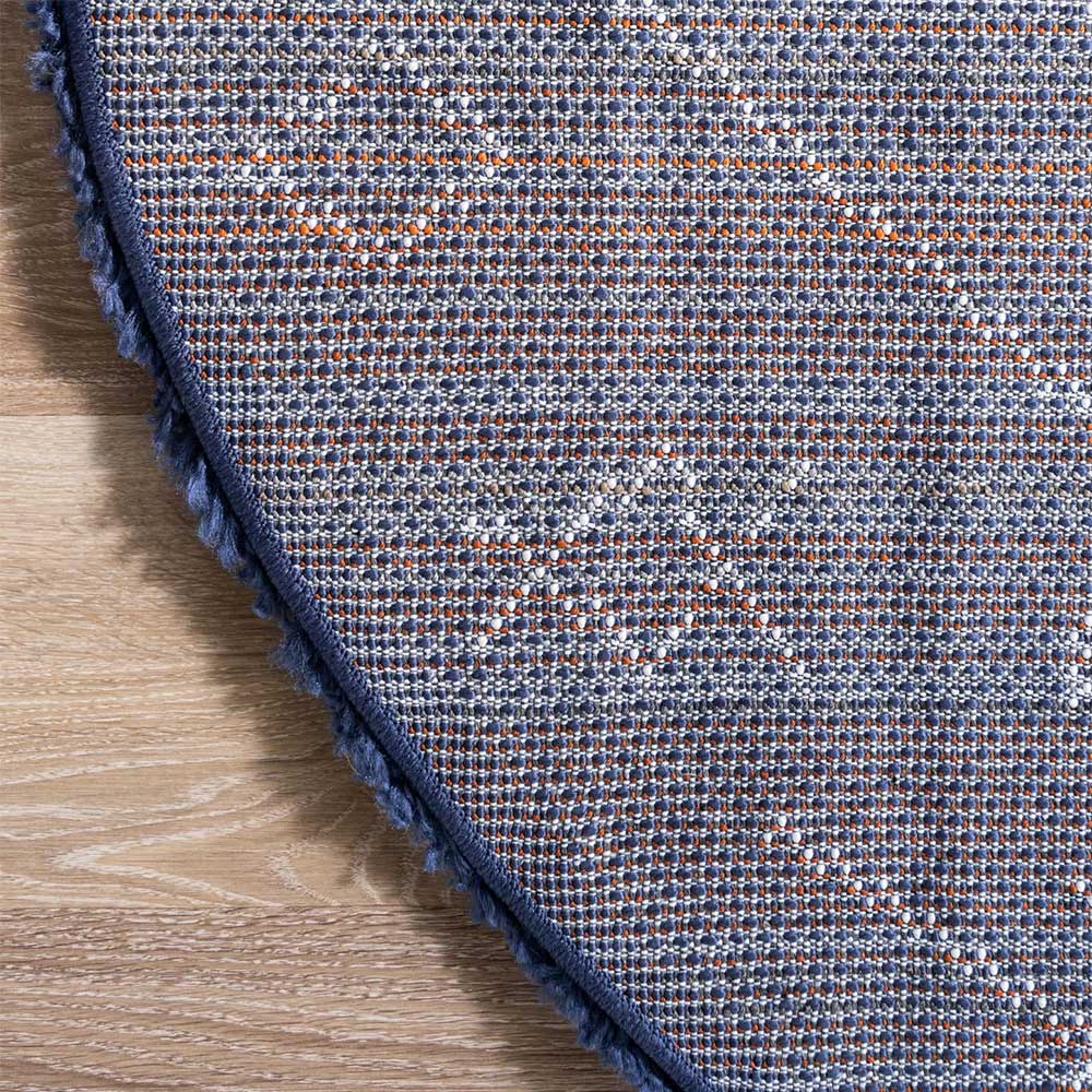 Rückseite des runden blauen Teppichs mit gewebter Struktur und Randabschluss – Myron