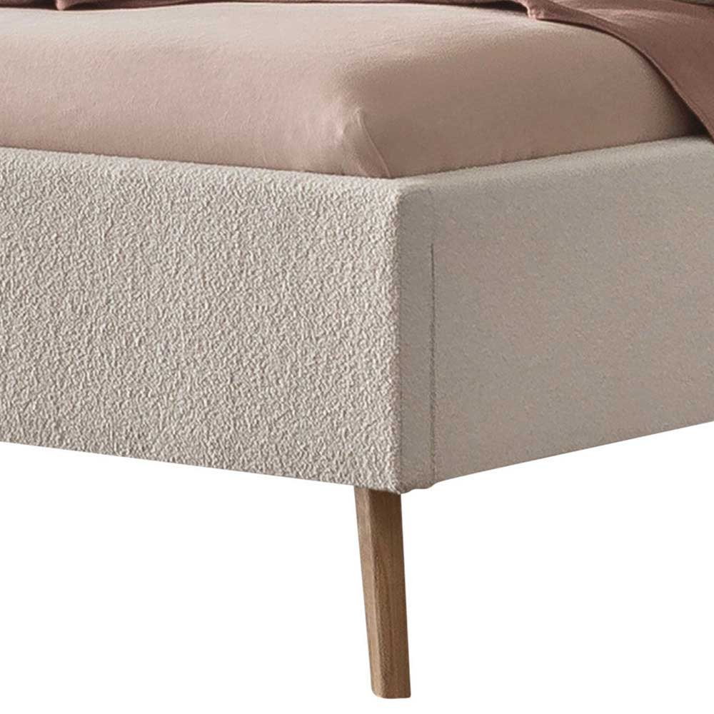 Fußteil des Polsterbetts in Creme Boucle mit konischen Holzfüßen im Skandi Design – Jandaria