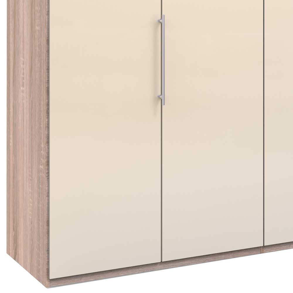 Detailansicht des Falttürenschranks mit heller Holzoptik Rahmen, cremefarbener Hochglanztür und Metallgriff – Rativian