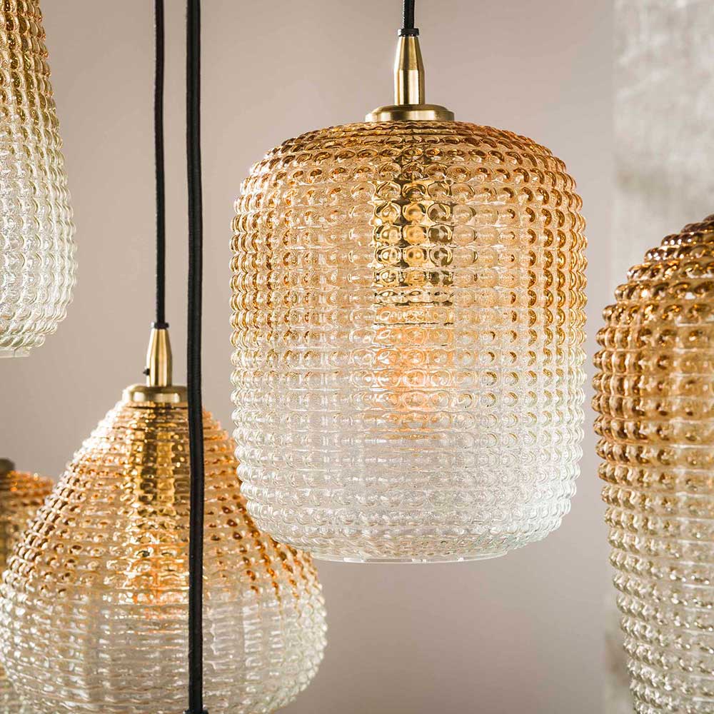 Detailansicht eines bernsteinfarbenen Lampenschirms aus strukturiertem Glas mit goldener Fassung – Gestina