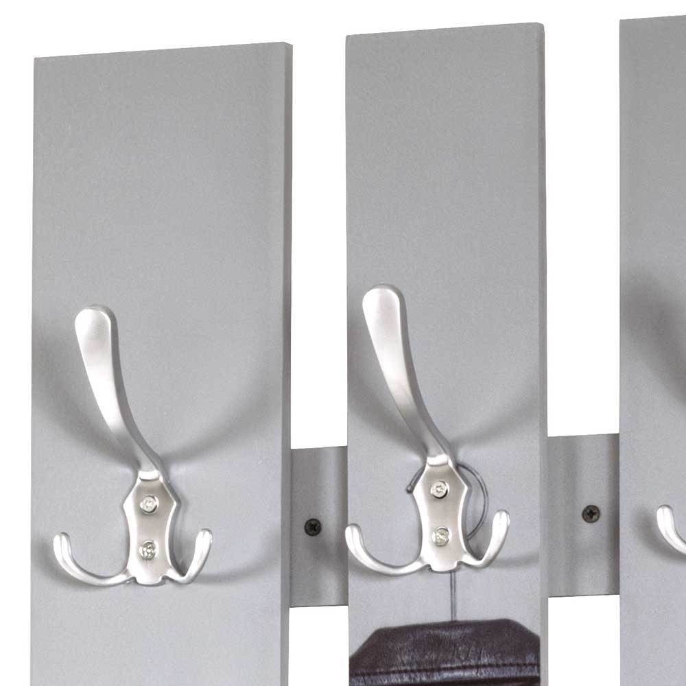 Silberne Doppel-Kleiderhaken auf den grauen Paneelen der modernen Wandgarderobe im Detail – Jimdira