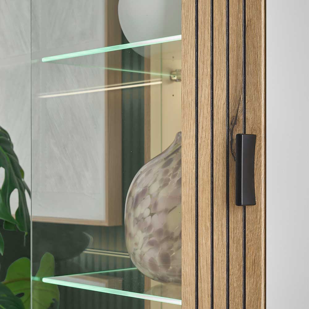 Beleuchtetes Vitrinenfach mit zwei Glasböden und vertikalen Holzlamellen im Schrank – Nenaloro