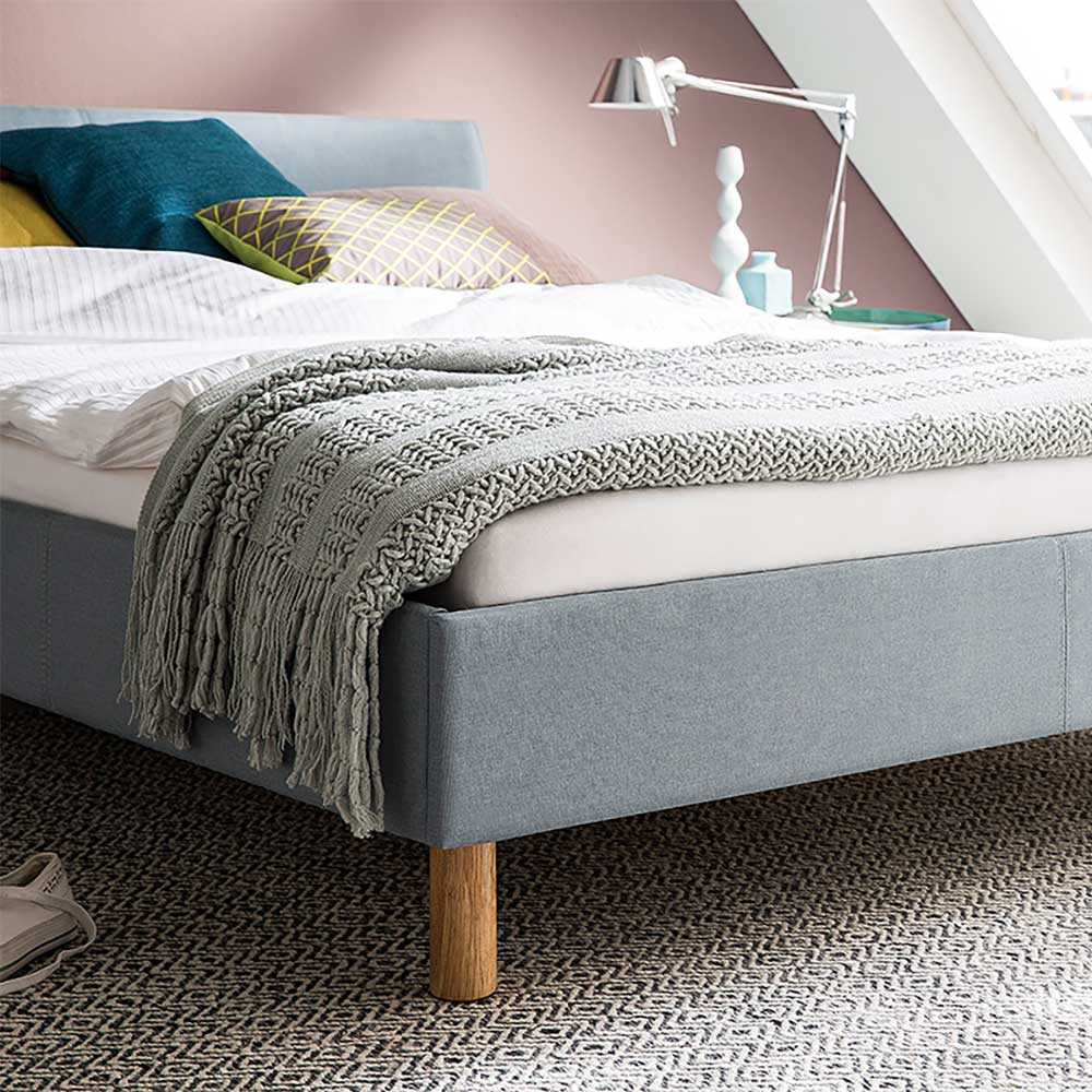Modernes Polsterbett in Hellblau mit Webstoffbezug und runden Holzfüßen im Schlafzimmer – Ortava