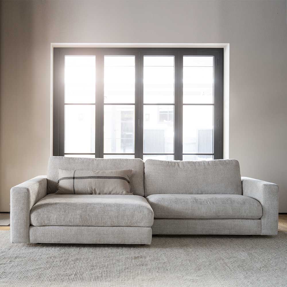 Hellgraue Polsterecke aus Stoff mit Chaiselongue und Kissen in Wohnzimmer – Esmen