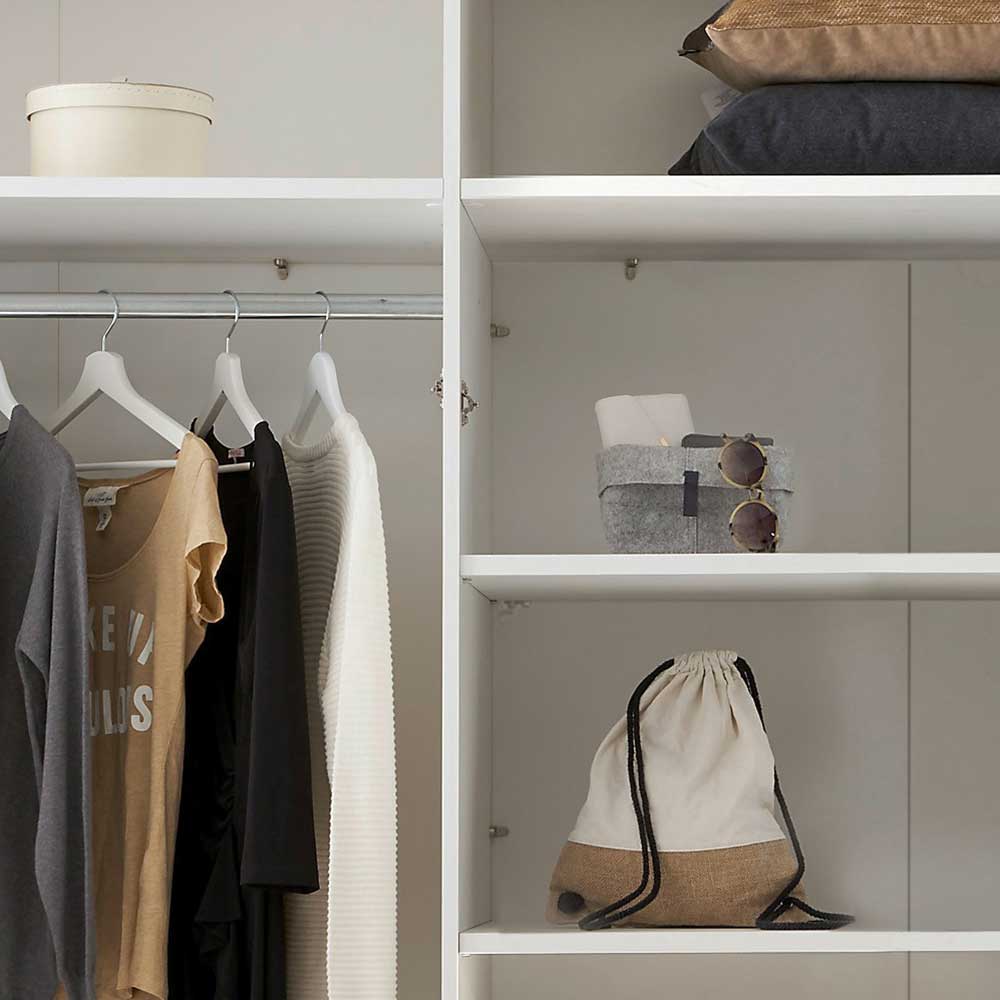 Innenansicht des Schranks mit aufgehängter Kleidung und praktischen Einlegeböden für Accessoires – Maggio