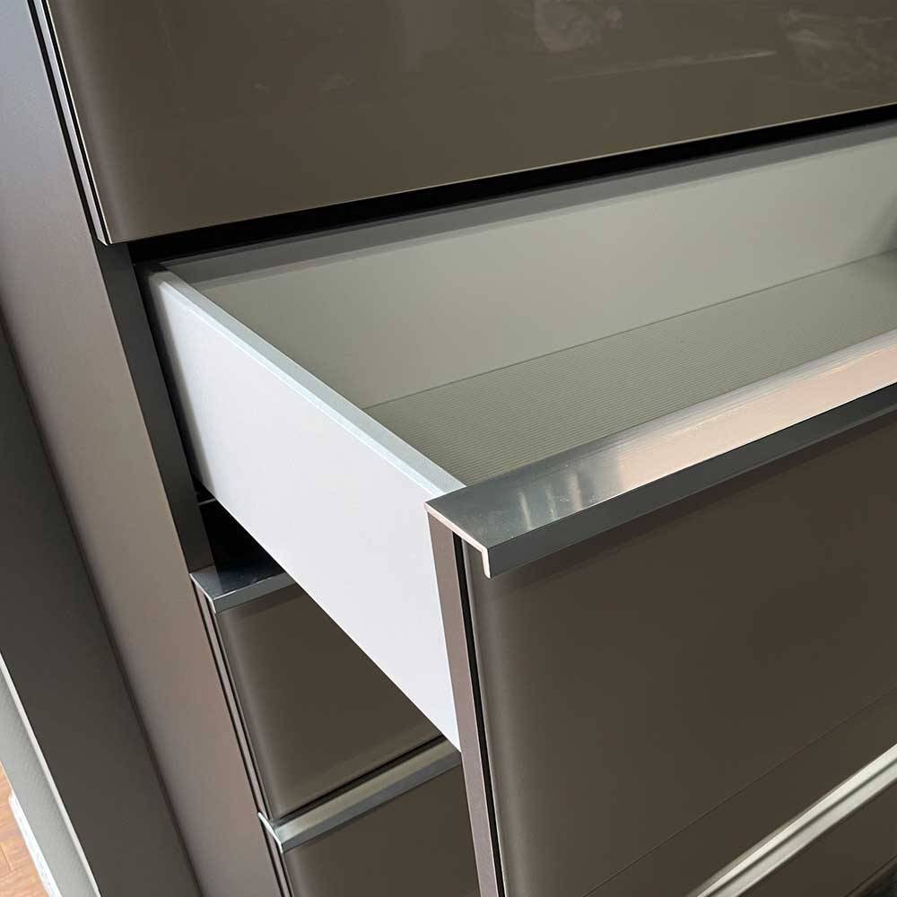 Offene Schublade der braunen Kommode mit silber-grauem Streifendekor im Inneren – Madita