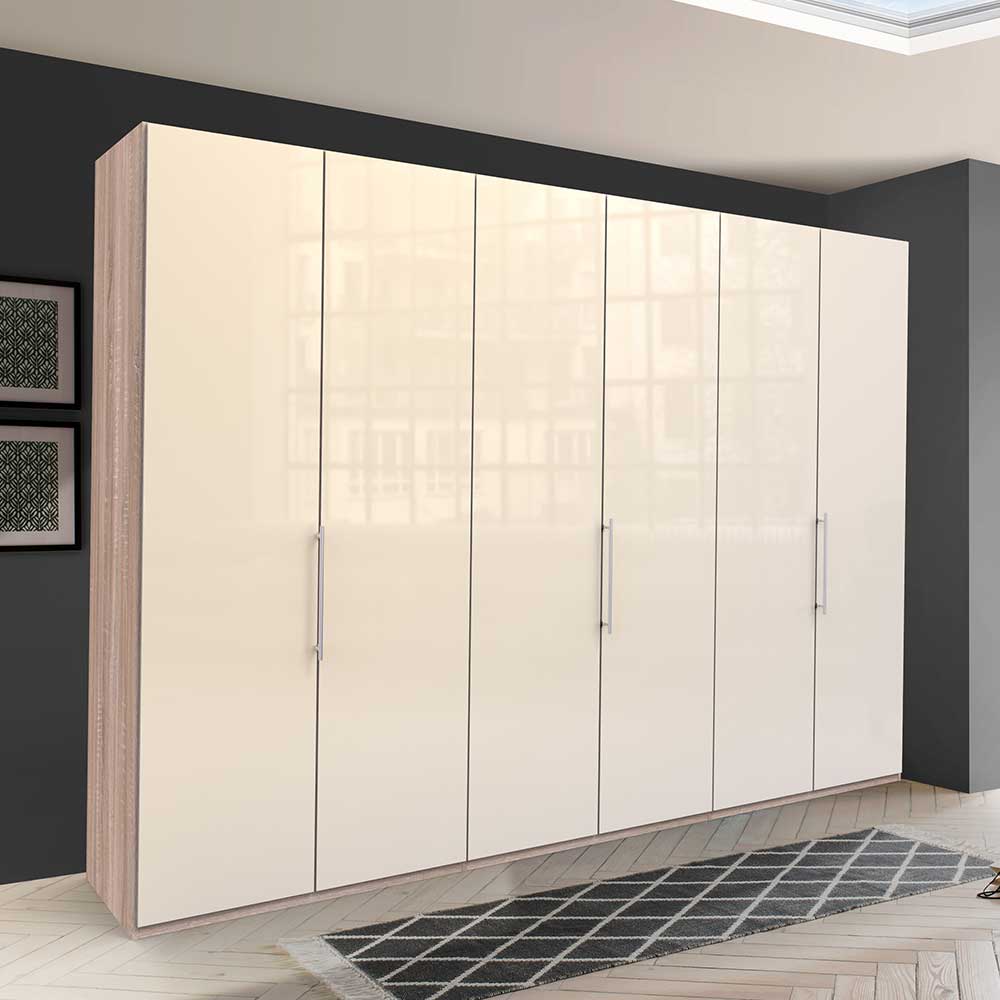 Großer Falttürenschrank mit cremefarbener Hochglanz-Glasfront und heller Holzoptik, silberne Griffe – Rativian