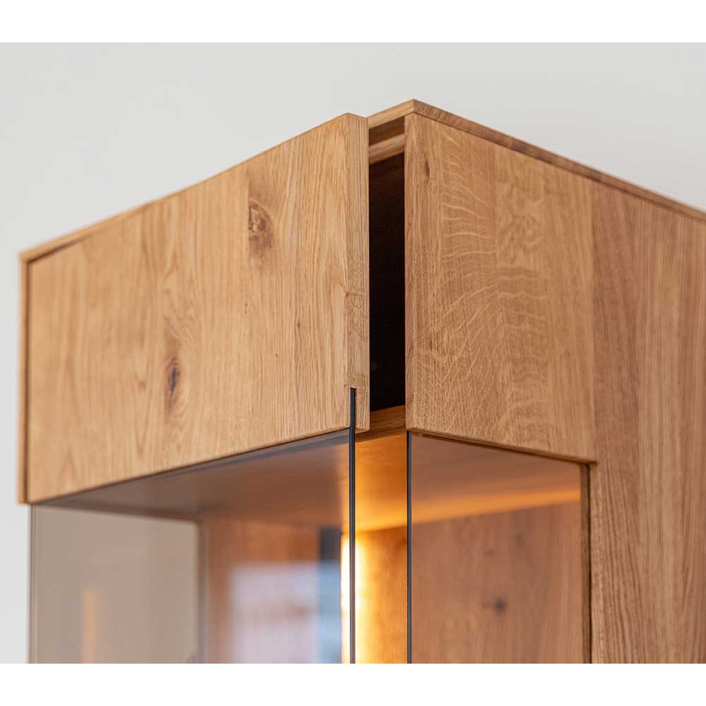 Oberer Eckbereich der Holzvitrine mit integrierter Glastür und feiner Maserung – Cocondar