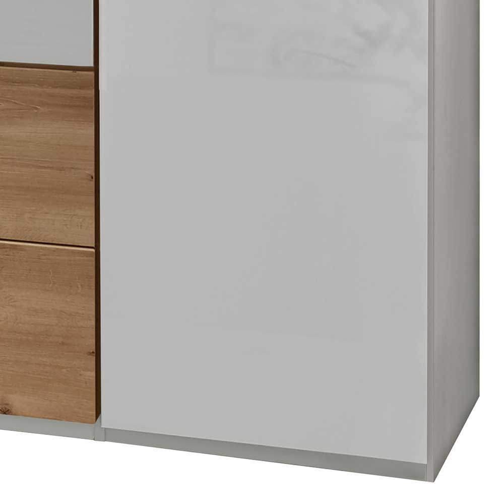 Seitenansicht des Schlafzimmerschranks in weiß hochglanz mit unteren Schubladen in Holzoptik – Malvido
